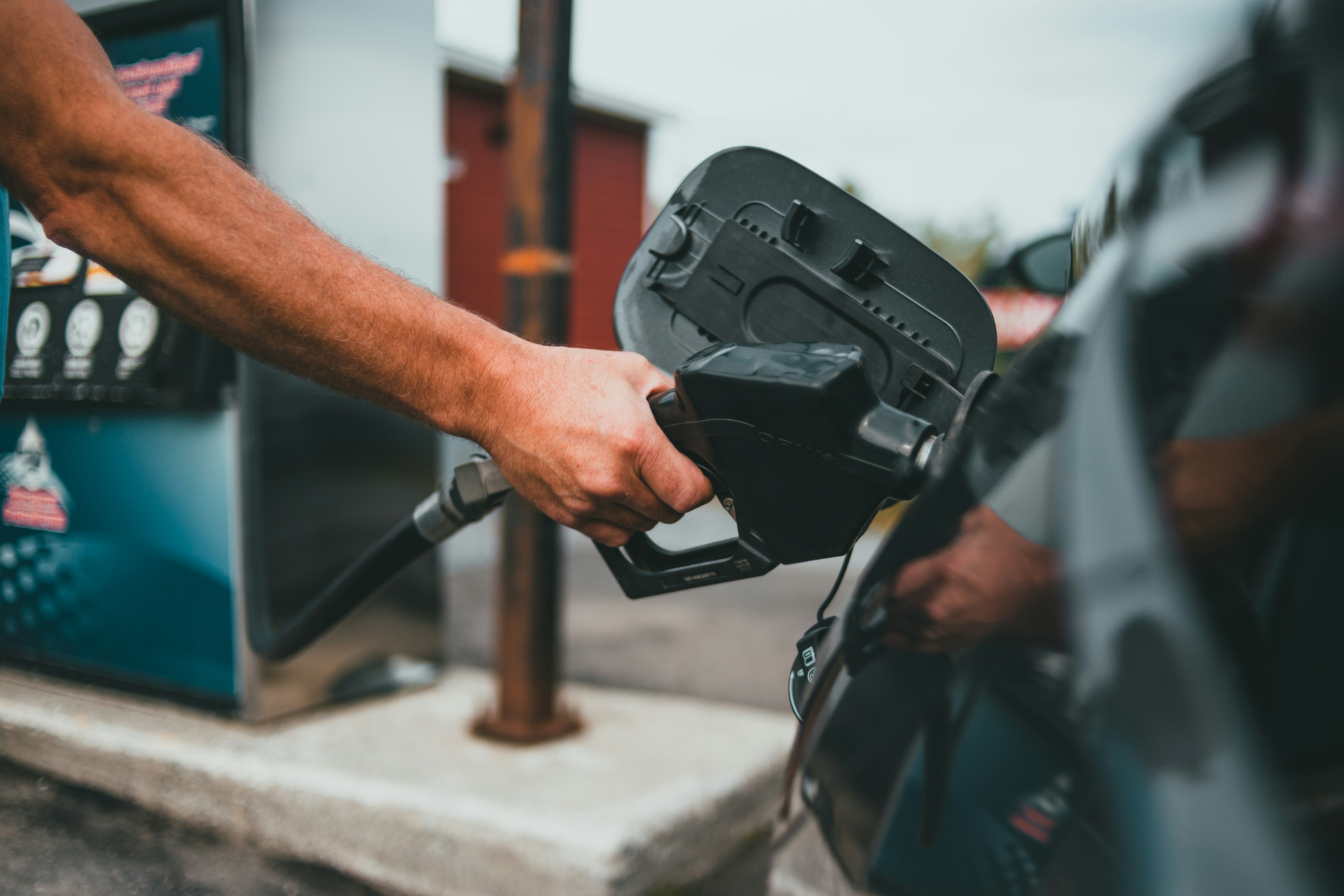 Personne en train de faire le plein d'essence dans un véhicule au Costa Rica. Trois options différentes de carburant : gasoil, super, regular