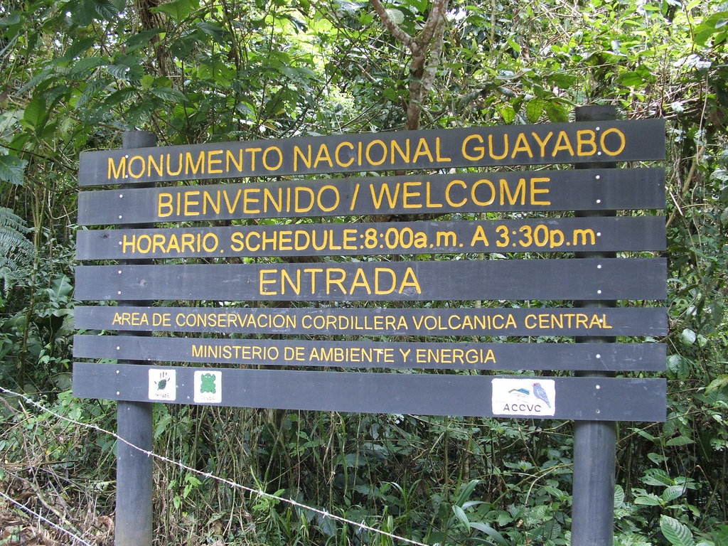 Panneau situé à l'entrée du parc national de Guayabo indiquant les horaires de visite et donnant la bienvenue